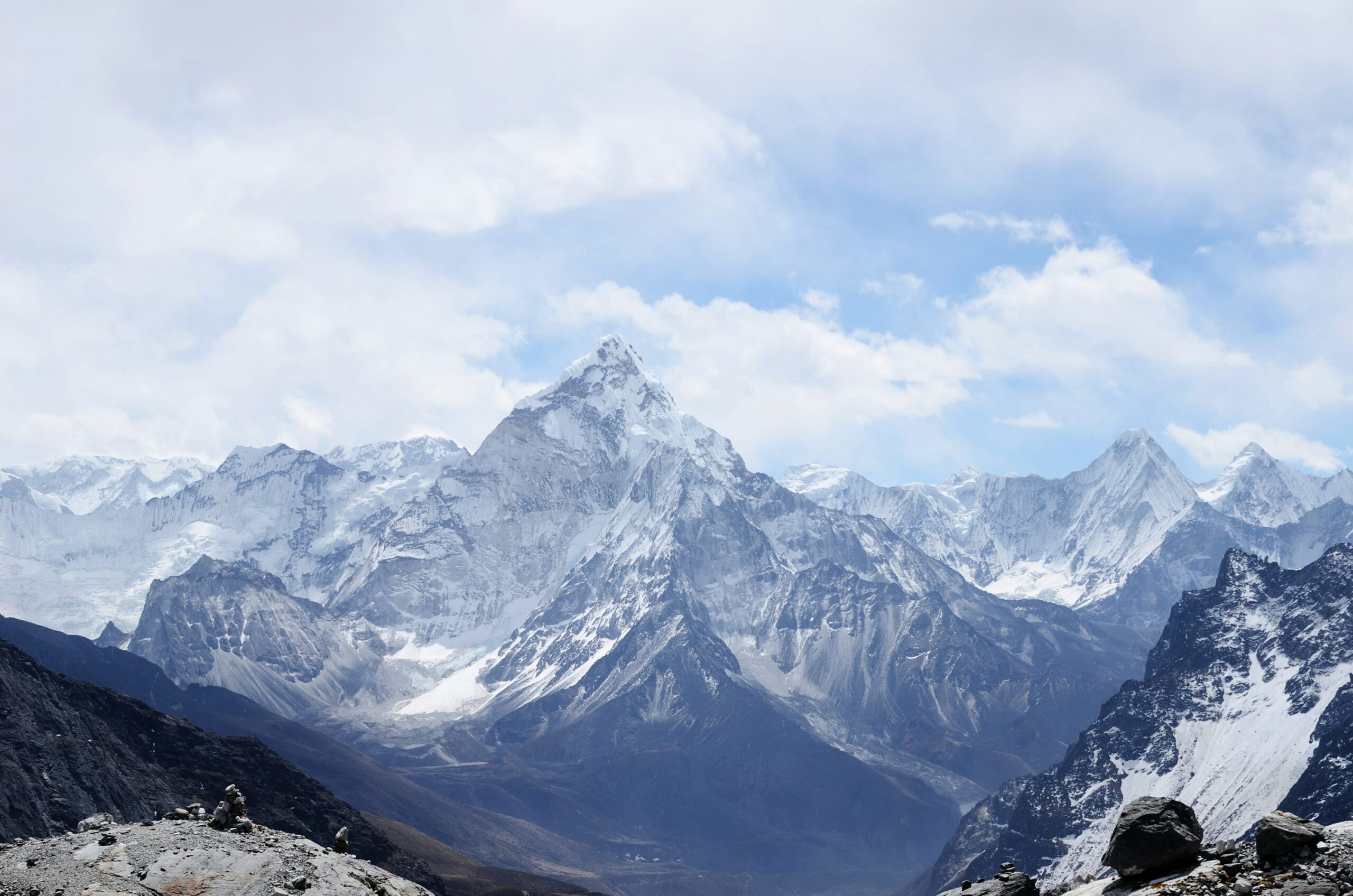 Aerial view of a snow-covered mountain range under a blue sky.